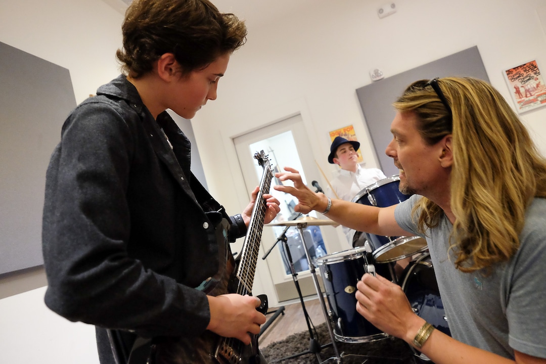 (Francisco Kjolseth  |  The Salt Lake Tribune)  Tega Hamlin, 13, gets a little guidance from Terence Hansen, Music Director at MusicGarage.org in Sugarhouse as kids take a break from rock and roll to learn some blues during a recent jam session.