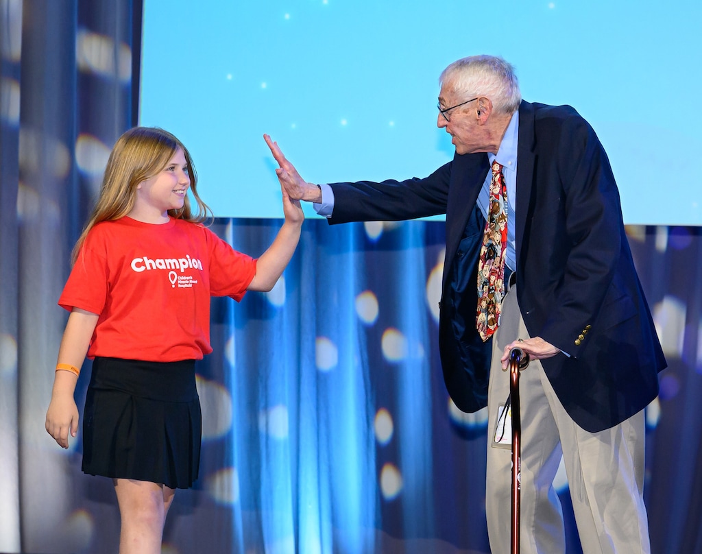 (Children's Miracle Network Hospitals) Joe Lake, right, co-founder of the nonprofit group Children's Miracle Network Hospitals, shares a high-five with a child at a 2023 event for the organization. Lake has died at age 82.
