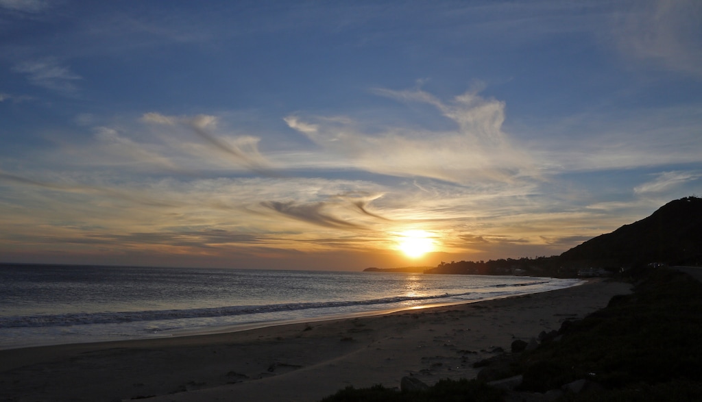 (Reed Saxon | The Associated Press) Smoke from the remnants of the Woolsey fire shrouds the sun as it sets over the Pacific Ocean, seen from Dan Blocker Beach along Pacific Coast Highway in Malibu in Southern California Tuesday, Nov. 13, 2018.