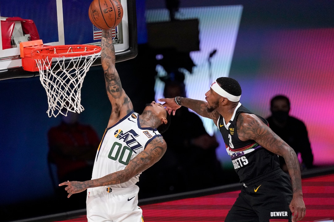 Utah Jazz's Jordan Clarkson (00) goes up for a shot as Denver Nuggets' Torrey Craig (3) defends during the first half an NBA first round playoff basketball game, Tuesday, Sept. 1,2020, in Lake Buena Vista, Fla. (AP Photo/Mark J. Terrill)