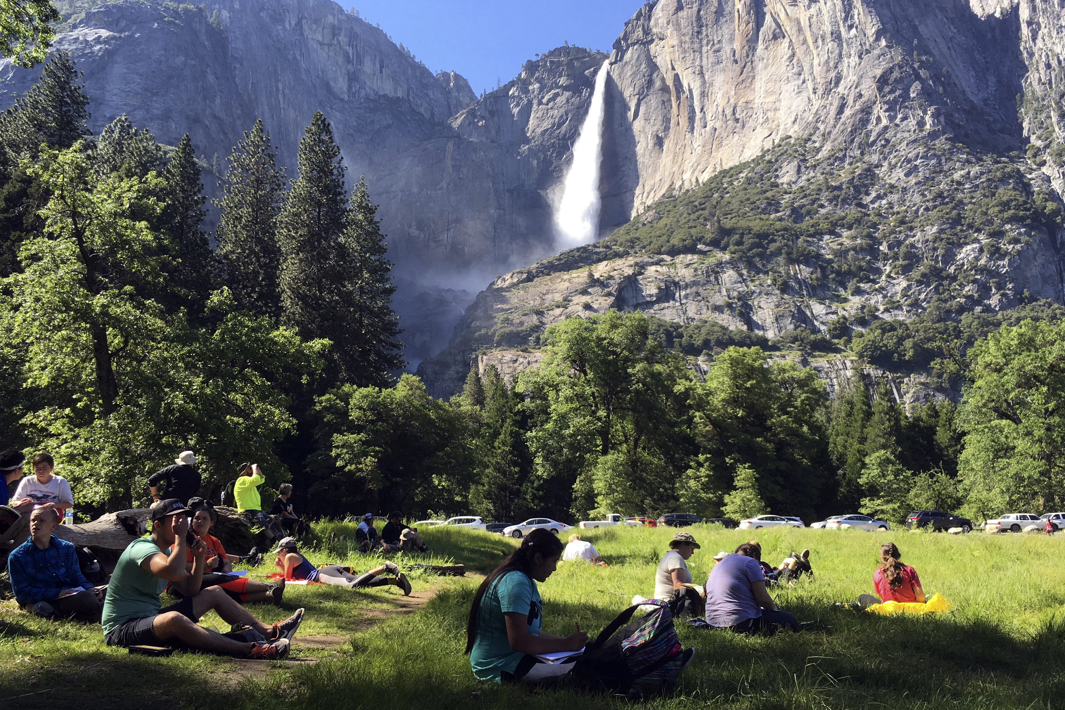 FILE - In this May 25, 2017 file photo, a class of eighth-grade students and their chaperones sit in a meadow at Yosemite National Park, California. (AP Photo/Scott Smith, File)