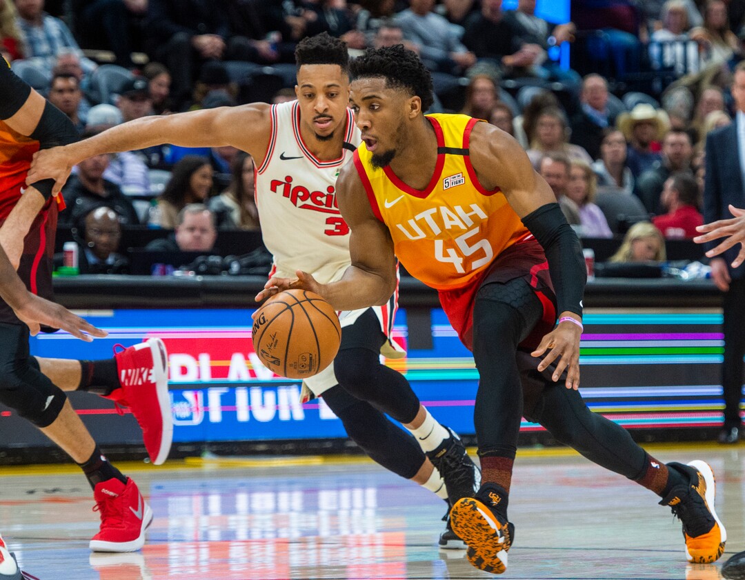 (Rick Egan  |  The Salt Lake Tribune)     Utah Jazz guard Donovan Mitchell (45) takes the ball up the middle, as Portland Trail Blazers guard CJ McCollum (3) defends, in NBA action between the Utah Jazz and thePortland Trail Blazers in Salt Lake City, Friday, Feb. 7, 2020.