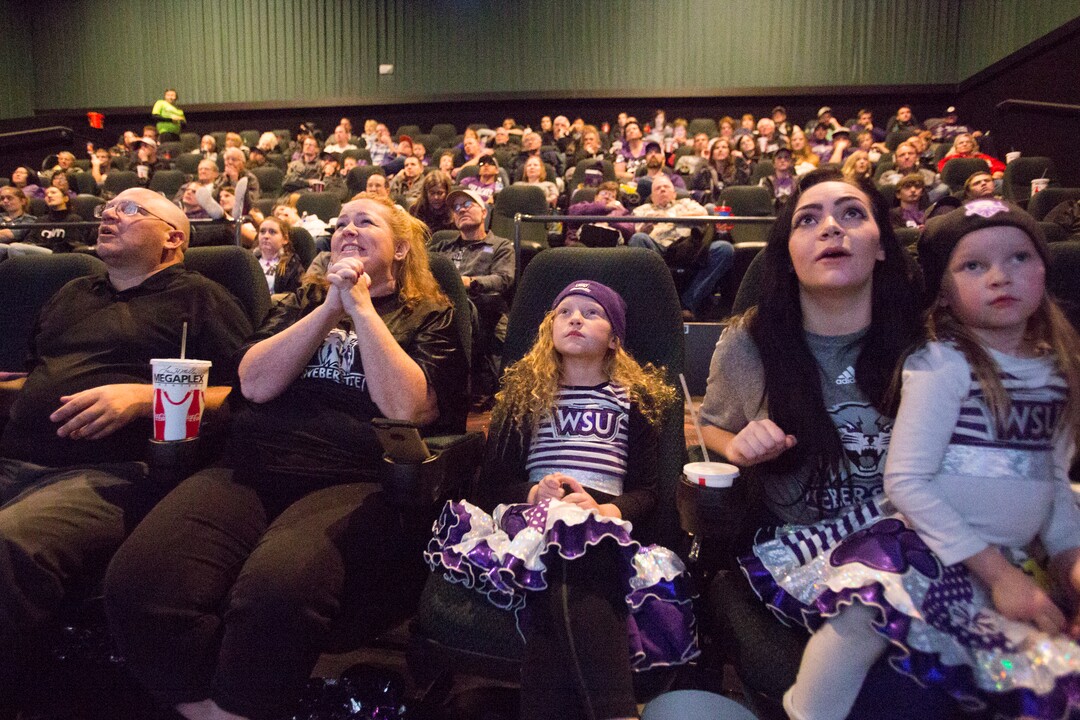 Rex Baxter, Jenn Baxter, Izzy Baxter, 9, Alexx Baxter, and Nyxx Baxter, 5, from left, alongside family and fans react after a play while watching television coverage of Weber State playing James Madison in the quarterfinals of the FCS NCAA college football playoffs, Friday, Dec. 8, 2017, in Ogden, Utah. (Matt Herp/Standard-Examiner via AP)
