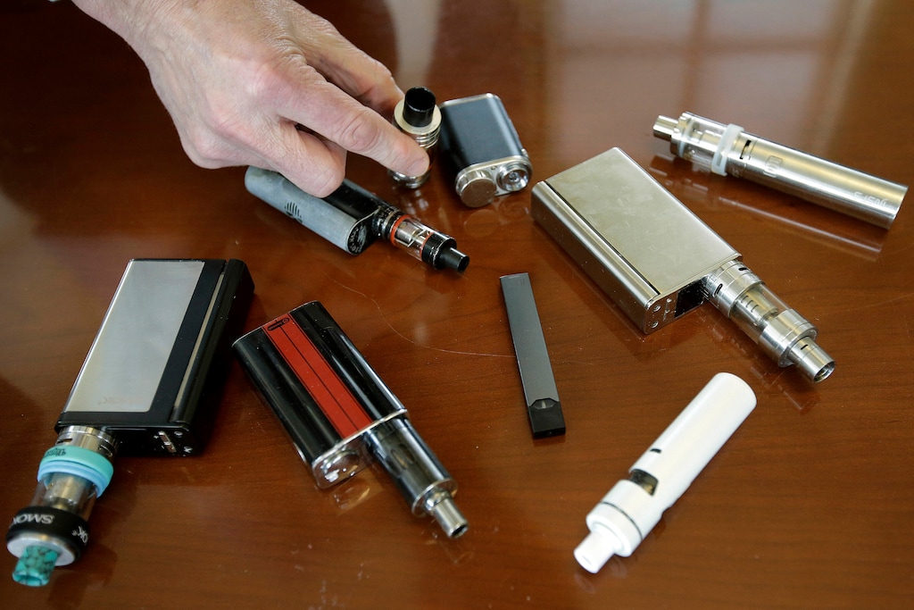 (Steven Senne | AP Photo) this Tuesday, April 10, 2018 photo, a high school principal displays vaping devices that were confiscated from students at the school in Massachusetts. On Thursday, Sept. 26, 2019, the Centers for Disease Control and Prevention said 805 confirmed and probable cases have been reported to have a vaping-related breathing illness, and the death toll has risen to 13.