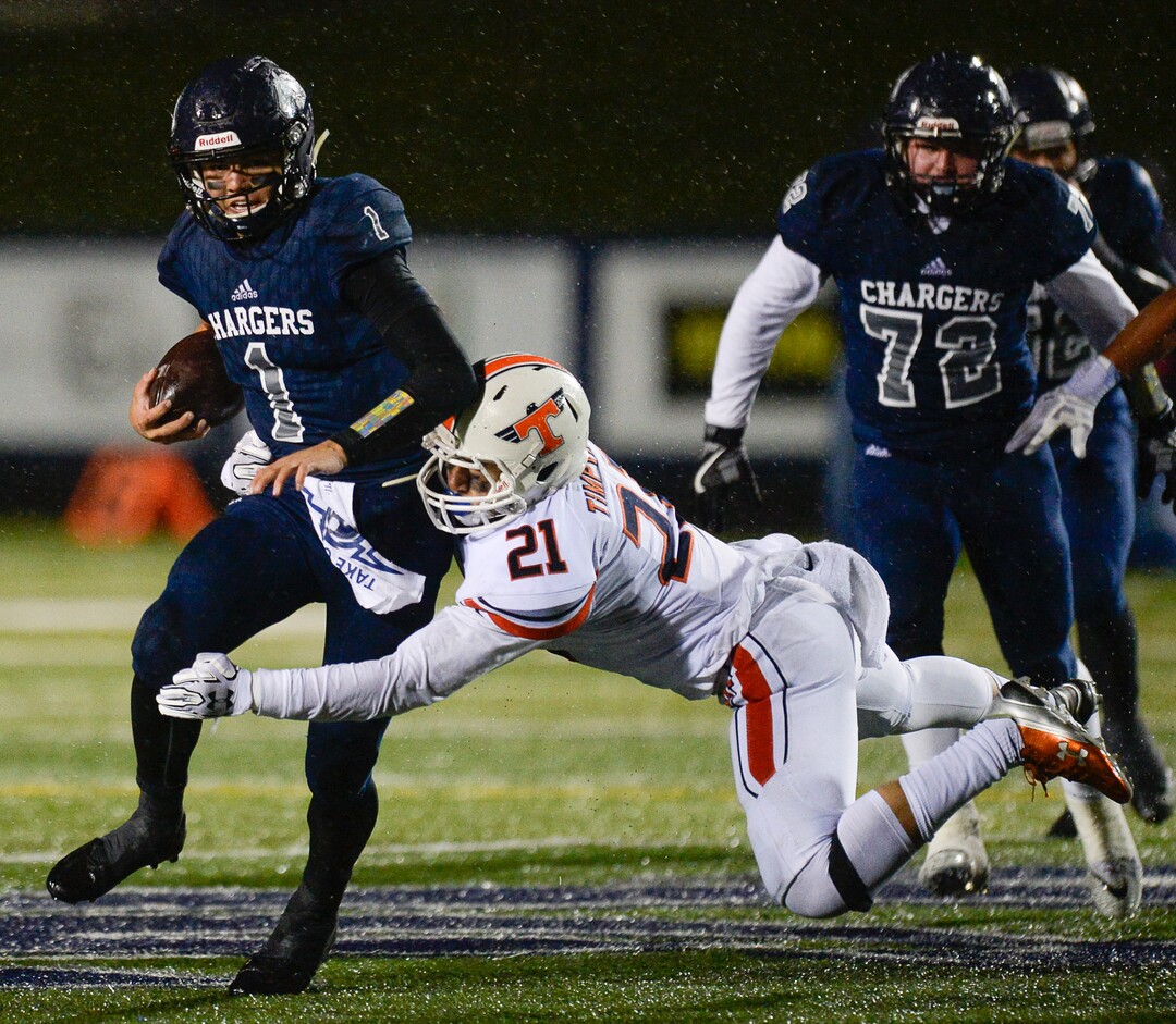 (Francisco Kjolseth  |  The Salt Lake Tribune)  Corner Canyon quarterback Zach Wilson puts in a few yards before being taken down by Karene Reid of Timpview in game action between Timpview at Corner Canyon on Thursday, Sept. 21, 2017.