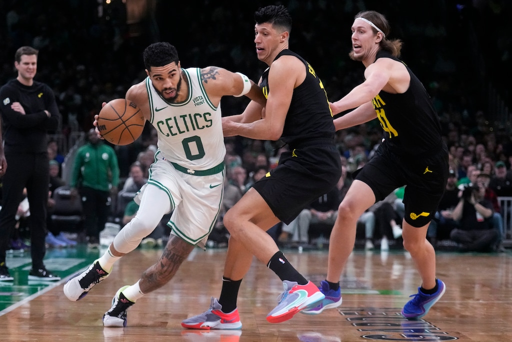 Boston Celtics forward Jayson Tatum (0) breaks free of Utah Jazz forward Simone Fontecchio, center, and forward Kelly Olynyk, right, on a drive to the basket during the second half of an NBA basketball game, Friday, Jan. 5, 2024, in Boston. (AP Photo/Charles Krupa)