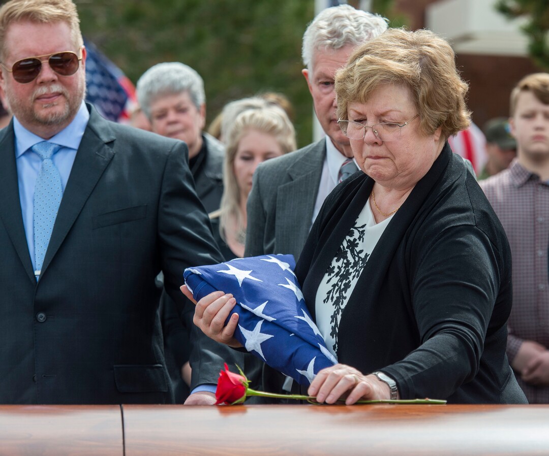 (Rick Egan  |  The Salt Lake Tribune)     Mary Ann Turner, the daughter of 2nd Lt. Lynn W. Hadfield, places a flower on his casket, during the graveside service for her father, who was killed during the Second World War, at Veterans Memorial Park, in Bluffdale. Thursday, March 21, 2019.