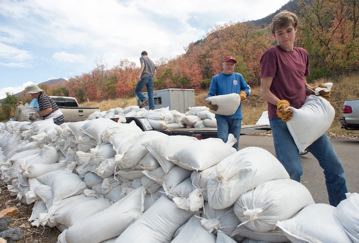 (Rick Egan  |  The Salt Lake Tribune)     Chris Brockbank and Jacob Harding, 17, helps their neighbors from Woodland Hills stack sandbags, Monday, Oct. 1, 2018.


