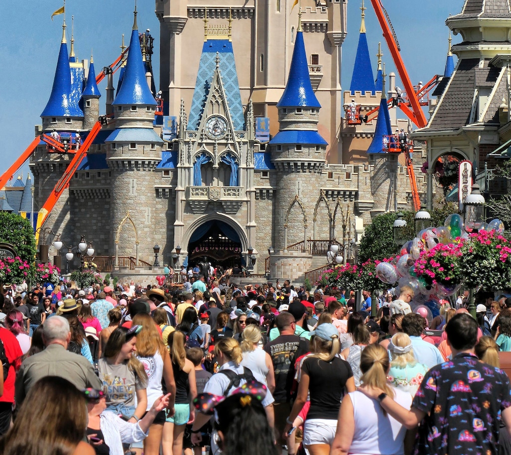 FILE - In this March 12, 2020, file photo, a crowd is shown along Main Street USA in front of Cinderella Castle in the Magic Kingdom at Walt Disney World in Lake Buena Vista, Fla. As Walt Disney World prepares to allow some third-party shops and restaurants to open at its entertainment complex later this week, it's posting a warning. While enhanced safety measures are being taken at Disney Springs, “an inherent risk of exposure to COVID-19 exists in any public place where people are present," the company said Monday, May 18, 2020, on a website for the entertainment complex.(Joe Burbank/Orlando Sentinel via AP, FIle)