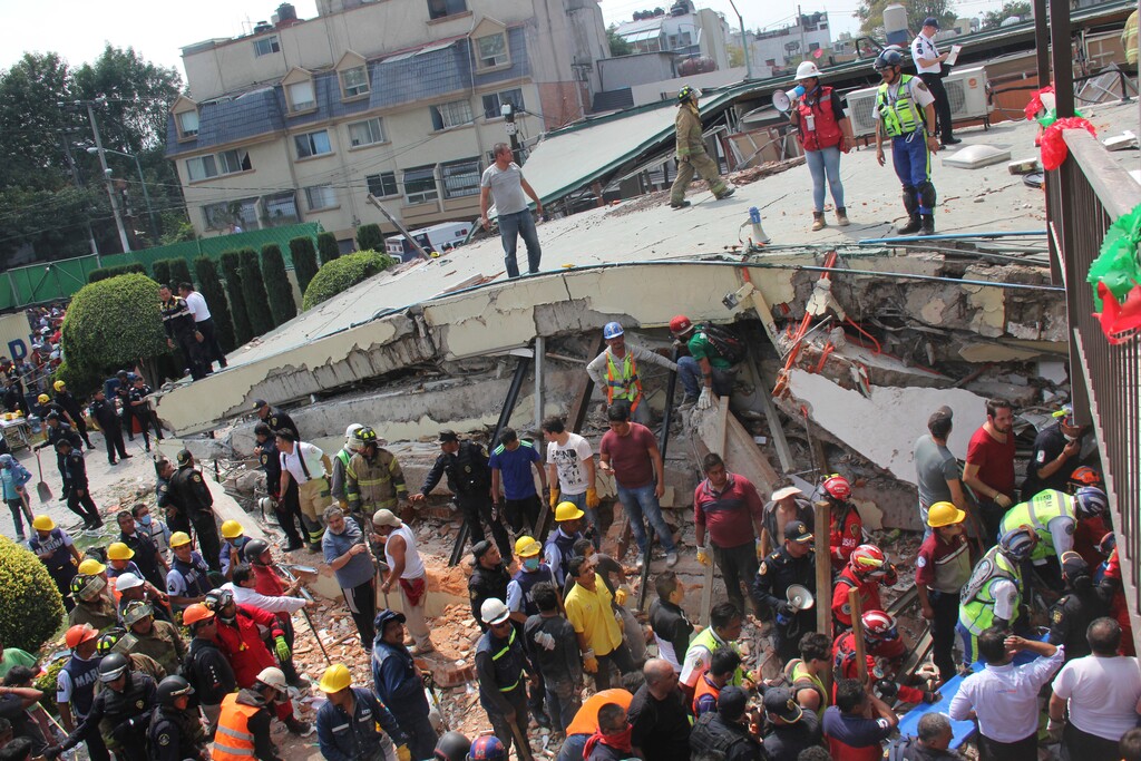 Rescue workers search for children trapped inside the collapsed Enrique Rebsamen school in Mexico City, Tuesday, Sept. 19, 2017. The earthquake stunned central Mexico, killing more than 100 people as buildings collapsed in plumes of dust. (AP Photo/Carlos Cisneros)