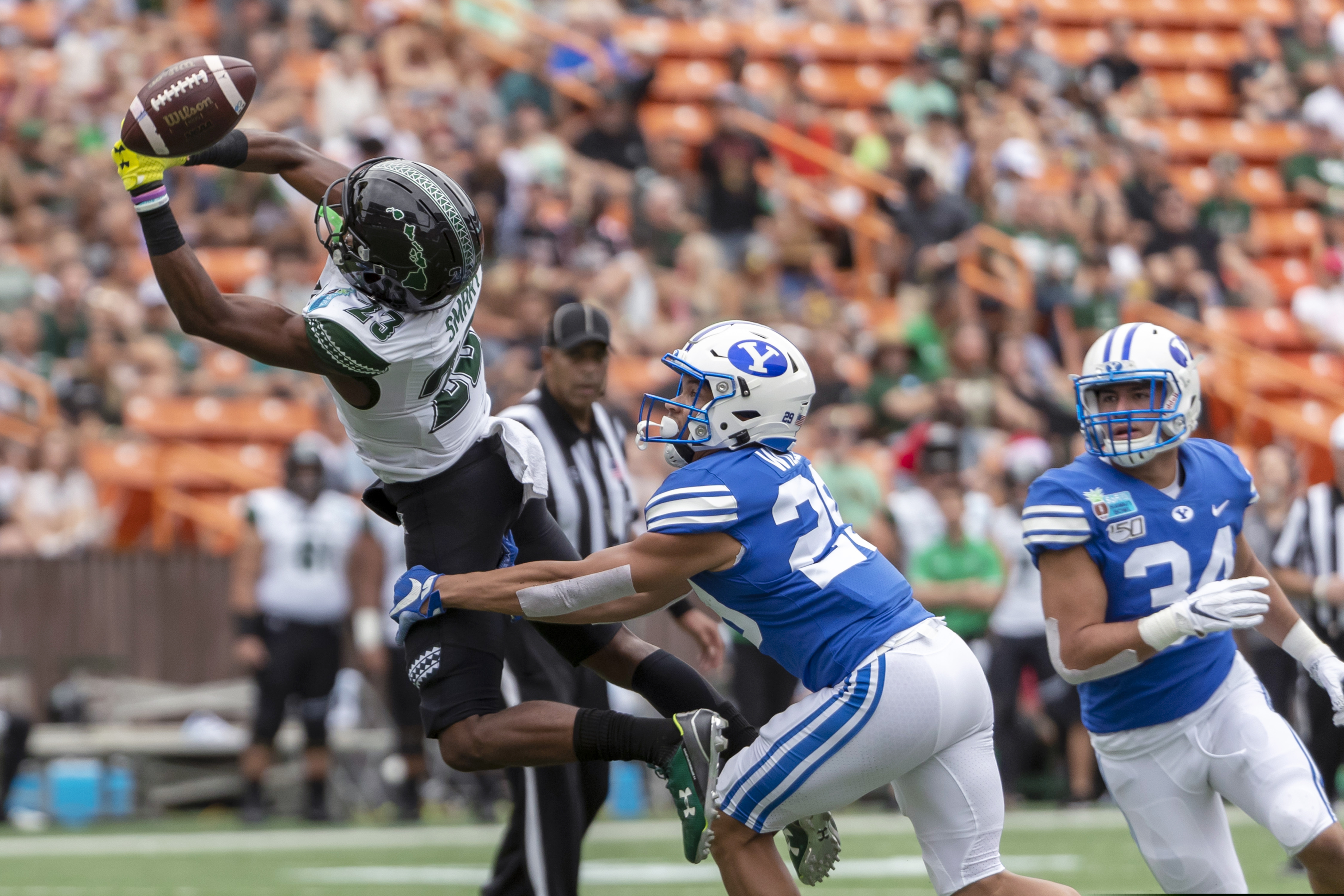 The football is just out of reach of Hawaii wide receiver Jared Smart (23) as BYU defensive back Shamon Willis (29) and linebacker Kavika Fonua (34) defend during the first half of the Hawaii Bowl NCAA college football game Tuesday, Dec. 24, 2019, in Honolulu. (AP Photo/Eugene Tanner)