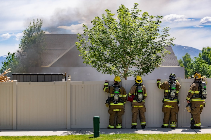 (Francisco Kjolseth | The Salt Lake Tribune) South Jordan firefighters check on the progress of the fire they started at the site of a former house where the owner stockpiled explosives. Residual explosives that remained in the basement of the home and could not be safely removed  had to be burned off on Tuesday, June 1, 2021.