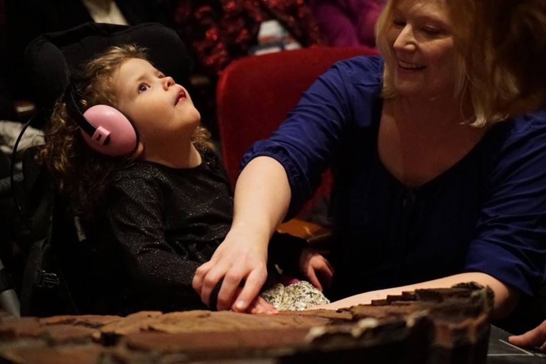 (Photo courtesy Utah Opera) A young visually impaired music lover is equipped with a headset at a dress rehearsal for Utah Opera's production of Mozart's "The Magic Flute" at Salt Lake City's Capitol Theatre. The headset allows the visually impaired to hear a translator deliver a play-by-play description of the stage action during the performance.