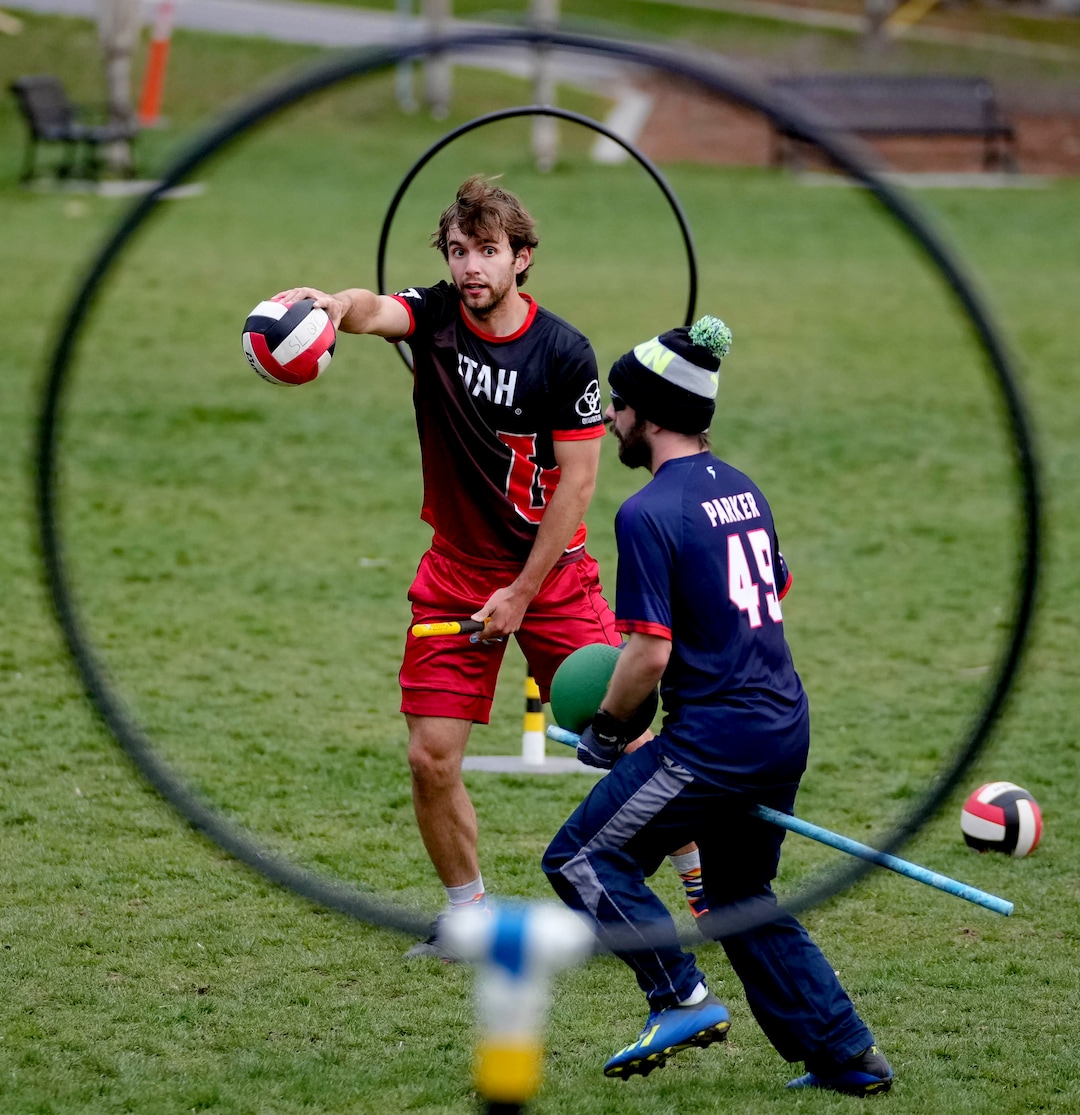 (Francisco Kjolseth | The Salt Lake Tribune) Porter Birchum, left, and Matthew Parker are framed by the scoring hoops as they play Quidditch at Reservoir Park in Salt Lake City on Wednesday, April 13, 2022. A small group of fans of the Harry Potter inspired game are preparing for next weeks US Quidditch 2022 National Championships that will be held in Salt Lake City on April 23-24. 