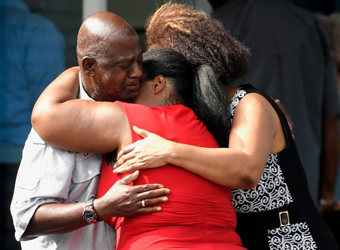 Leshea White and Kimberly Stallworth hug their uncle Roger Bracey, who was at Burnette Chapel Church of Christ when shots were fired, Sunday, Sept. 24, 2017, in Antioch, Tenn. They were reunited at another nearby church. (Andrew Nelles/The Tennessean via AP)