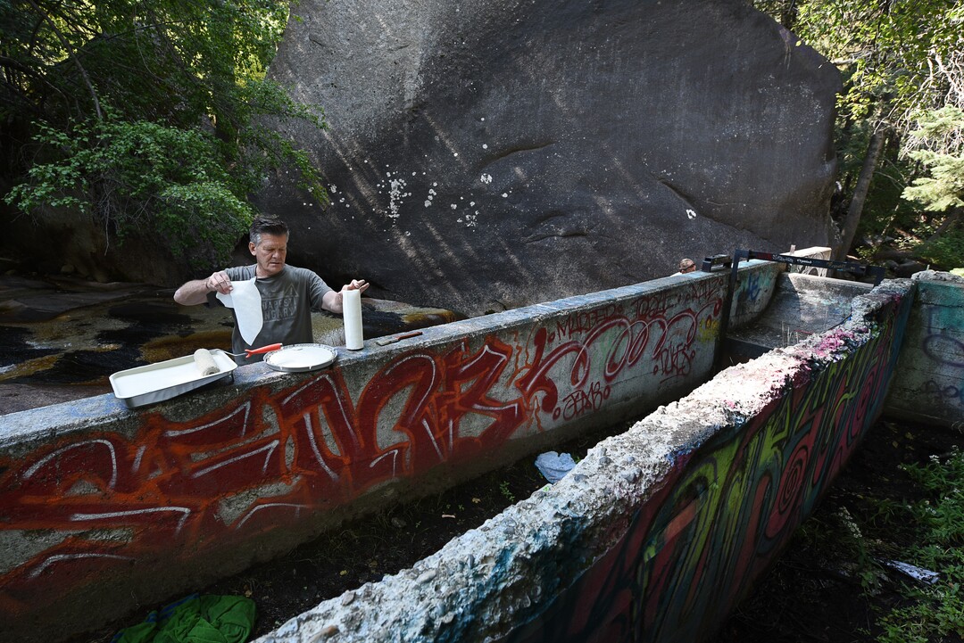 (Francisco Kjolseth  |  The Salt Lake Tribune)  Michel Nebeker works to cover up or clean up graffiti that has proliferated in lower Little Cottonwood Canyon, where vandals, often wielding cans of fluorescent-colored spray paint, have covered granite faces, trees and structures. The vandalism is particularly apparent along the Temple Quarry Trail and the creek at the Moon Rock swimming hole and former pavilion site. Volunteers using donated equipment and solvents spend thousands of hours removing the paint from the rocks only to see graffiti return to the same faces or on rock nearby.