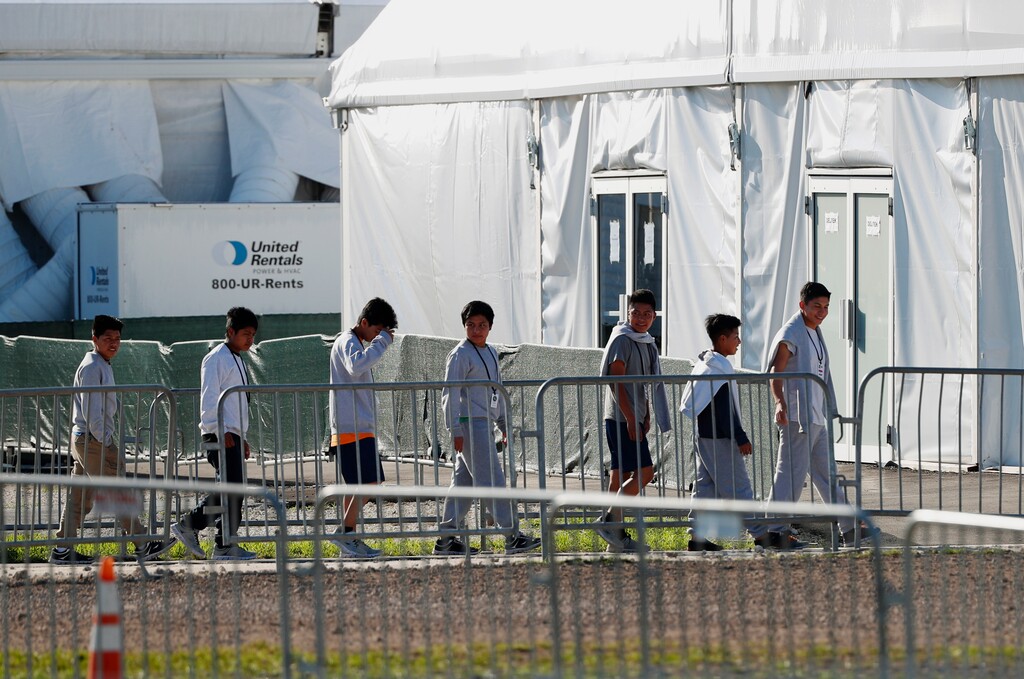(Wilfredo Lee | AP file photo) In this Feb. 19, 2019 photo, youngsters line up to enter a tent at the Homestead Temporary Shelter for Unaccompanied Children in Homestead, Fla. The Trump administration is canceling English classes, recreational programs, and legal aid for unaccompanied minors staying in federal migrant shelters nationwide, saying the immigration influx at the southern border has created critical budget pressures.