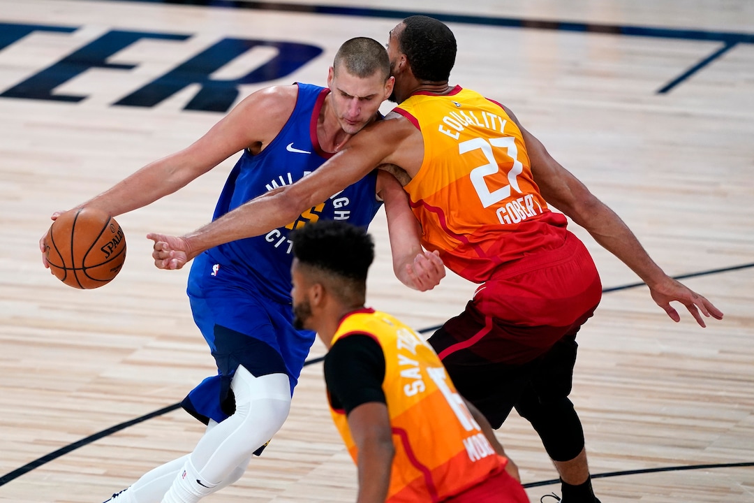 Utah Jazz's Rudy Gobert (27) defends as Denver Nuggets' Nikola Jokic drives during the first half of an NBA basketball first round playoff game Friday, Aug. 21, 2020, in Lake Buena Vista, Fla. (AP Photo/Ashley Landis, Pool)