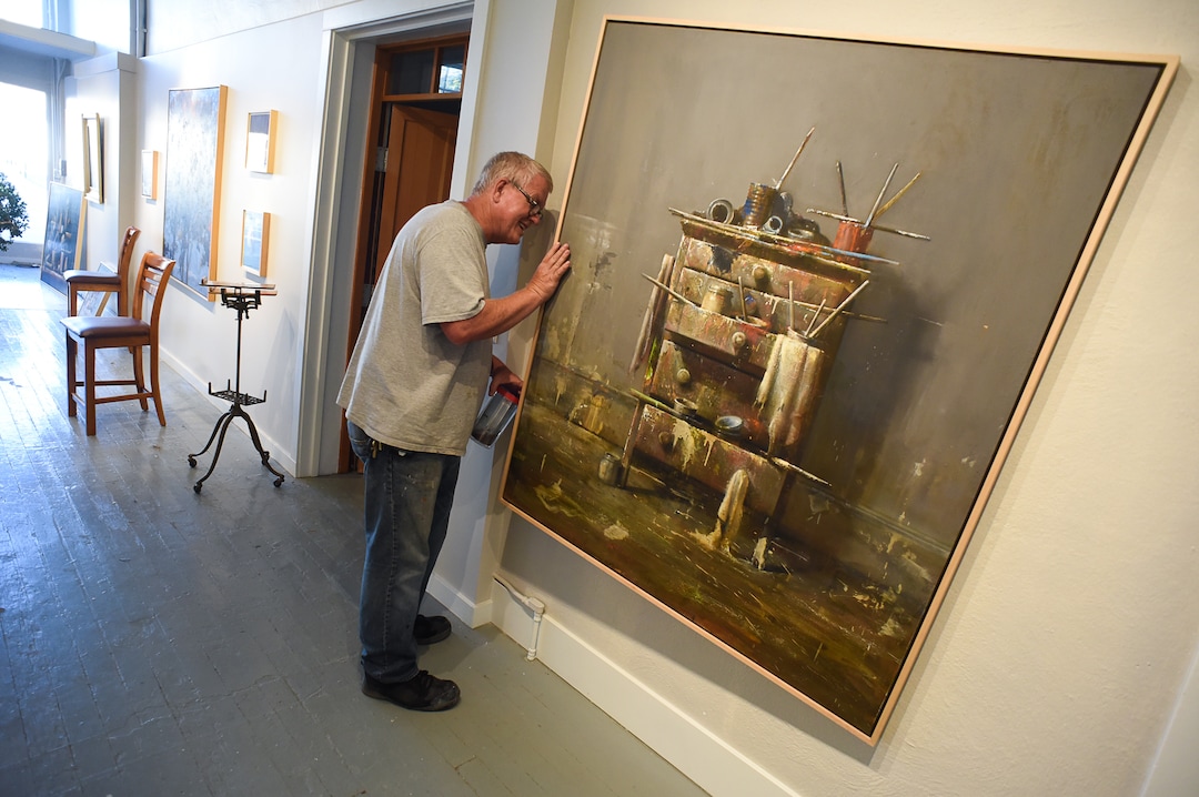 (Francisco Kjolseth  |  The Salt Lake Tribune)  Artist Dave Dornan peeks behind his painting entitled "Process" as he looks to see what year he completed it although admits he might add a few things. The former University of Utah art professor opened an art school in Helper and some of his students bought studios along Main Street.