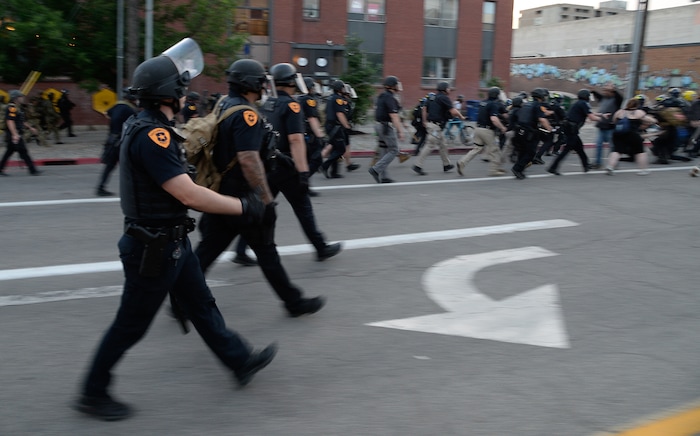 (Francisco Kjolseth  |  The Salt Lake Tribune) Police push forward along 300 East near the downtown library as they enforce a mandatory curfew in Salt Lake City on Monday, June 1, 2020, following violence and unrest over the weekend due to the death of George Floyd by police.