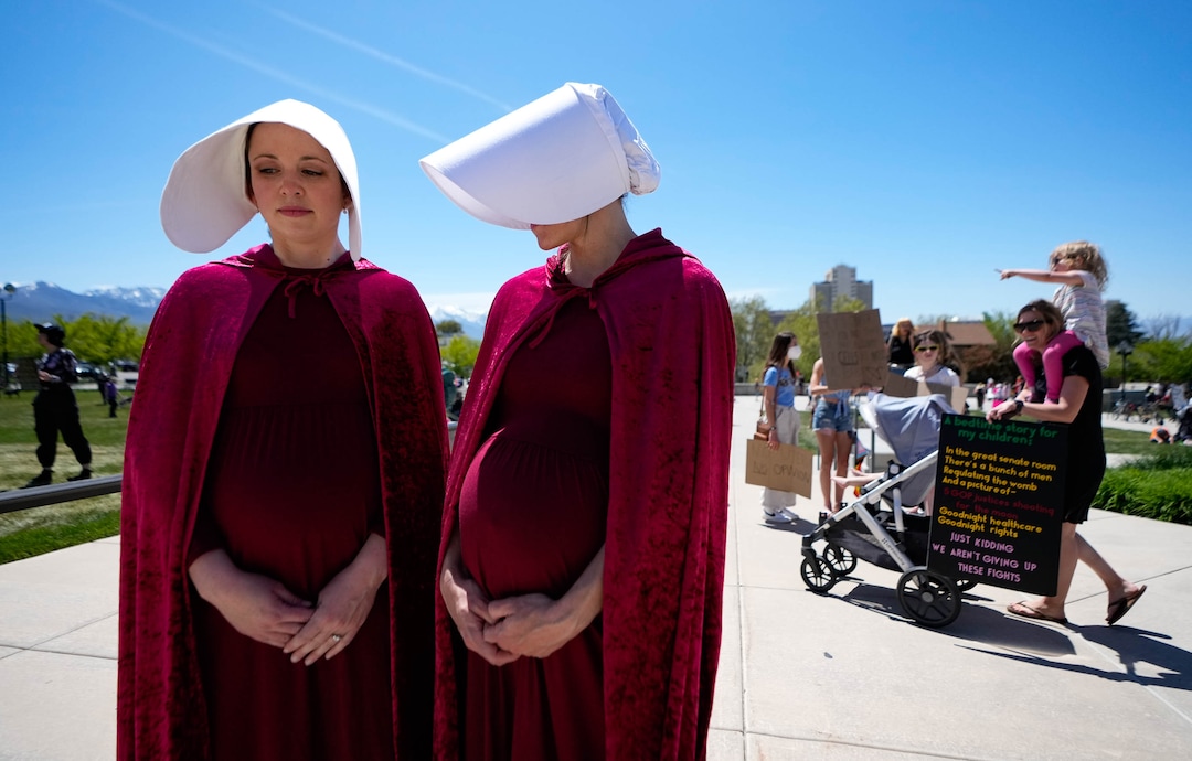 (Francisco Kjolseth | The Salt Lake Tribune) Alicia Ackerman, left, and Emily Sunderland dressed in costumes from "The Handmaid's Tale," a dystopian novel that describes a future where women are forced to give birth, join about 2,500 protesters at the Capitol for a “Bans Off Our Beehive” rally in support of abortion rights on Saturday, May 14, 2022.
