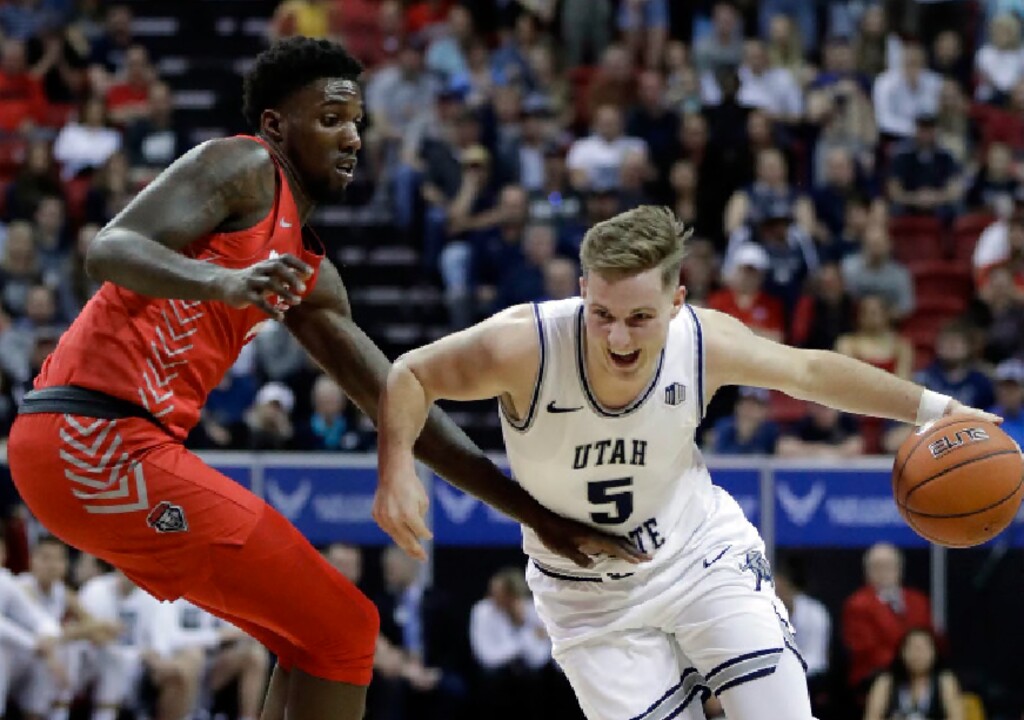 Utah State's Sam Merrill drives as New Mexico's Corey Manigault defends during the first half of a Mountain West Conference tournament NCAA college basketball game Thursday, March 5, 2020, in Las Vegas. (AP Photo/Isaac Brekken)