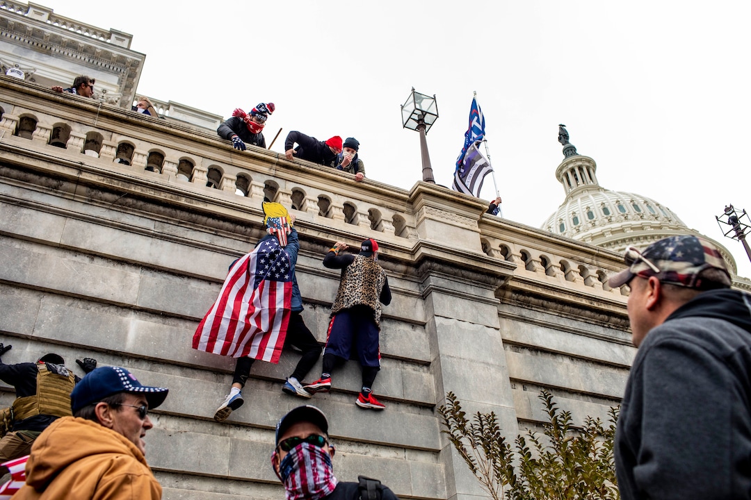 (Jason Andrew | The New York Times) Protestors climb the Capitol in Washington on Wednesday, Jan. 6, 2021. The Capitol building was placed on lockdown, with senators and members of the House locked inside their chambers, as Congress began debating President-elect Joe Biden’s victory. President Trump addressed supporters near the White House before protesters marched to Capitol Hill.