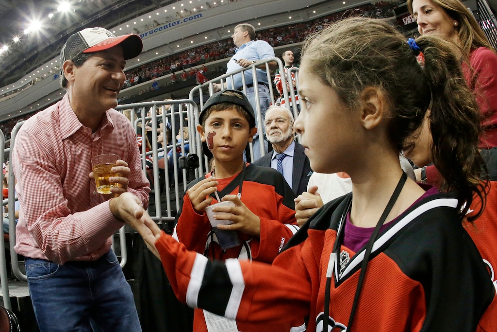 (Julio Cortez | AP) New Jersey Devils co-owner David Blitzer, left, celebrates with children after the Devils scored a goal against the New York Islanders during the second period of an NHL hockey game in 2013.