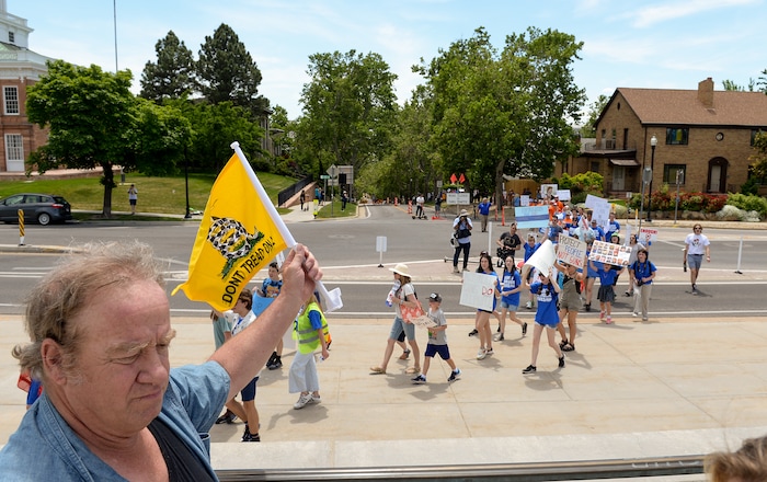 (Chris Samuels | The Salt Lake Tribune) A man holds a Gadsden flag in the air as marchers walk in support of increased gun safety measures at the Capitol in Salt Lake City, Saturday, June 11, 2022.