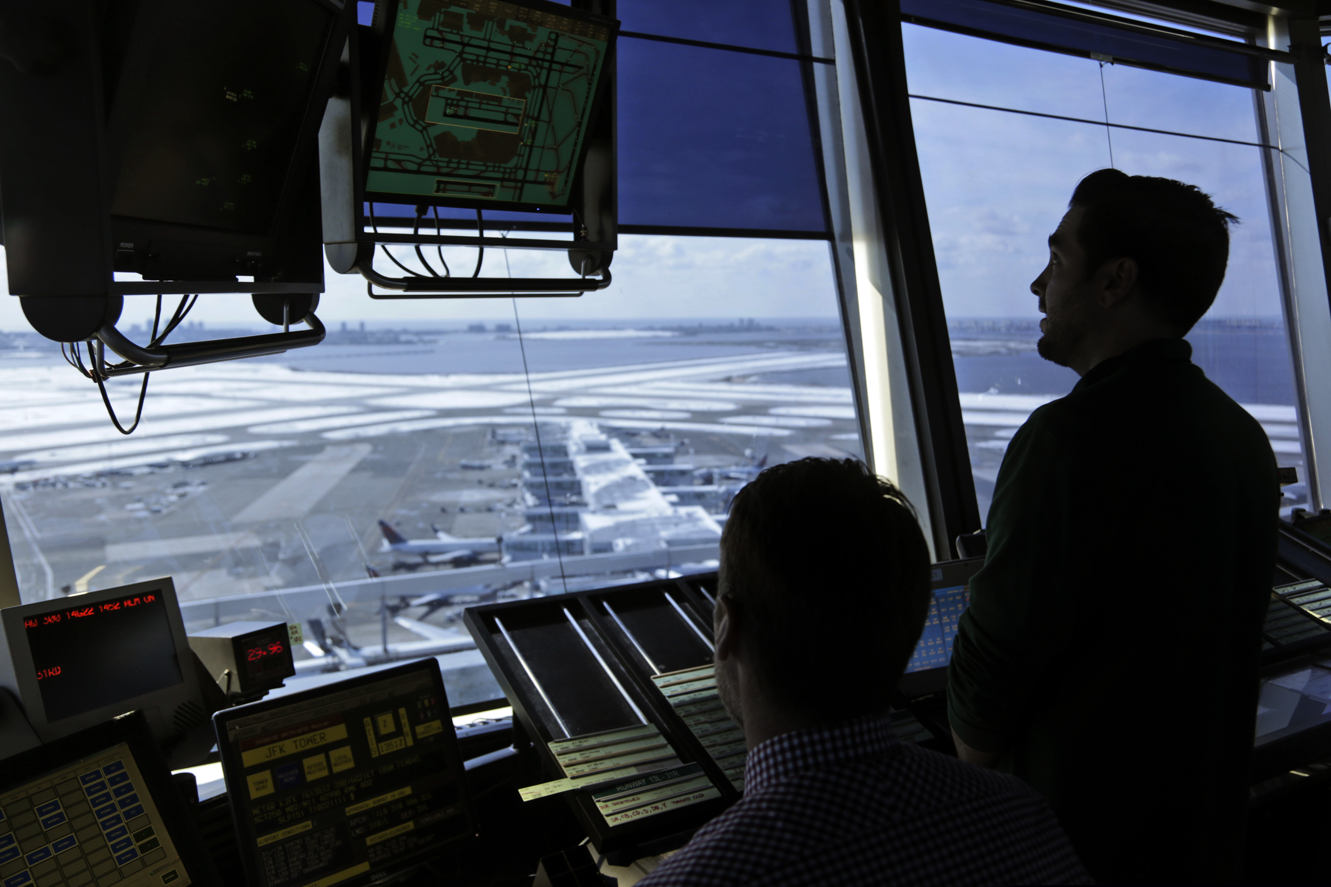 (AP Photo/Seth Wenig, File) In this March 16, 2017, file photo, air traffic controllers work in the tower at John F. Kennedy International Airport in New York. The partial government shutdown is starting to effect air travelers. Over the weekend, some airports had long lines at checkpoints, apparently caused by a rising number of security officers calling in sick while they are not getting paid.