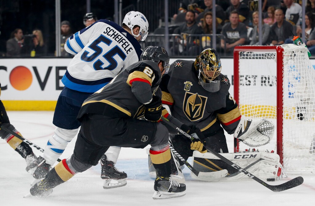 Vegas Golden Knights goaltender Marc-Andre Fleury, right, blocks a shot by Winnipeg Jets center Mark Scheifele (55) as center Cody Eakin watches during the first period of Game 4 of the NHL hockey Western Conference finals Friday, May 18, 2018, in Las Vegas. (AP Photo/John Locher)
