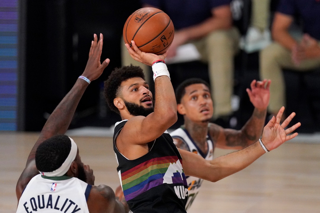 Utah Jazz's Royce O'Neale, left, and Jordan Clarkson, right, defend against a shot attempt by Denver Nuggets' Jamal Murray (27) during the first half an NBA first round playoff basketball game, Tuesday, Sept. 1,2020, in Lake Buena Vista, Fla. (AP Photo/Mark J. Terrill)