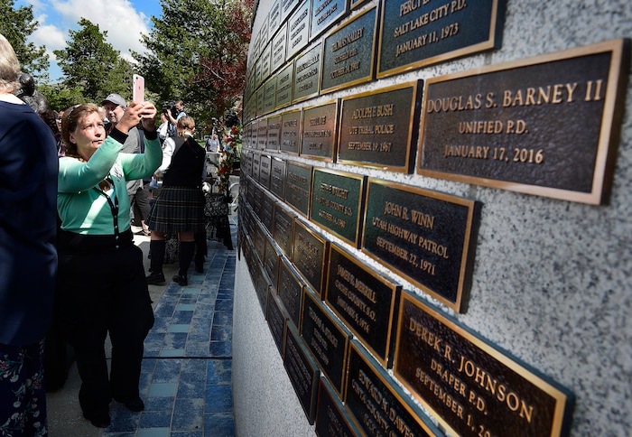(Scott Sommerdorf | The Salt Lake Tribune)
People make photos of the names on the memorial wall at the end of the Utah Law Enforcement Memorial honoring the 142 police officers killed in the line of duty during the state's history, Thursday, May 3, 2018.
No Utah law enforcement officer died in the line of duty last year.