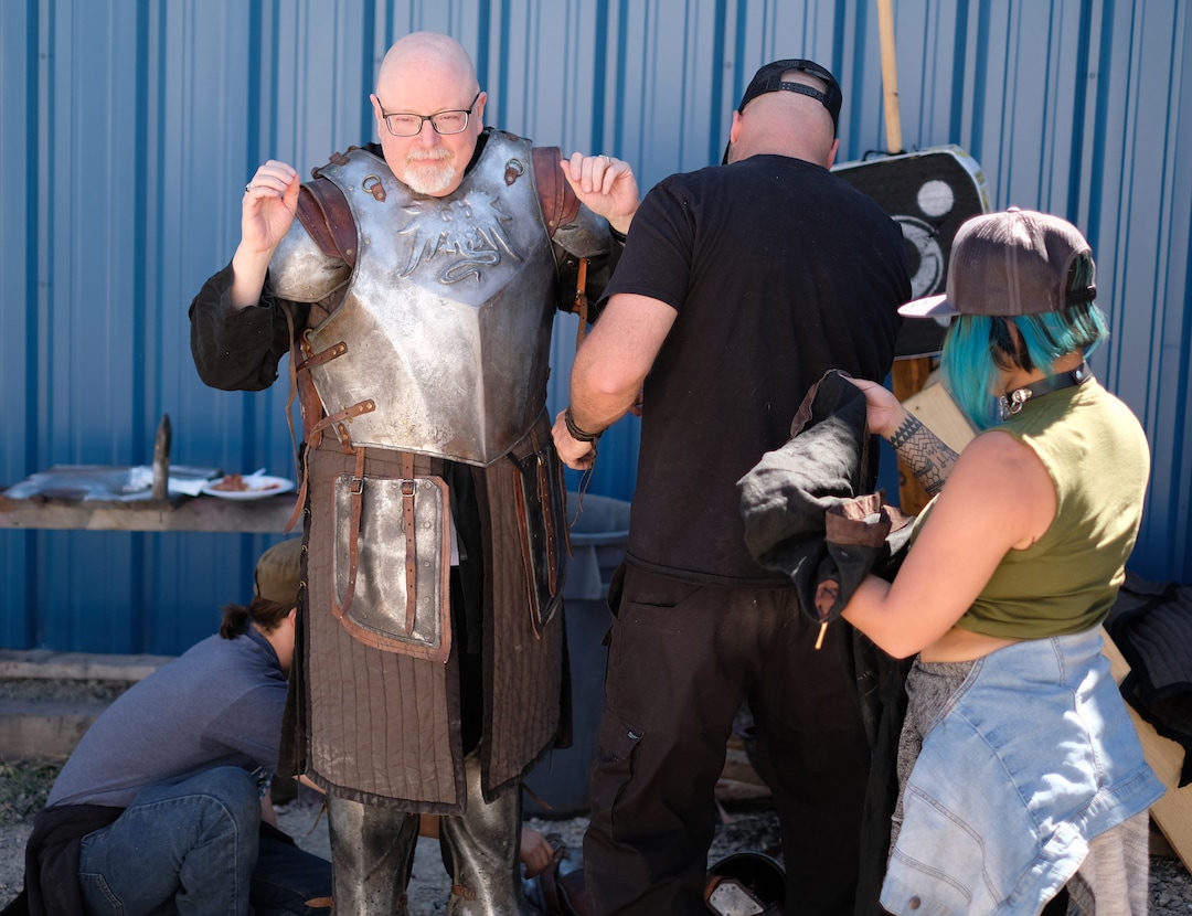 (Photo courtesy Doug Pasko) It takes a team to get Salt Lake Tribune TV critic Scott D. Pierce into a suit of armor on the set of “The Outpost.”