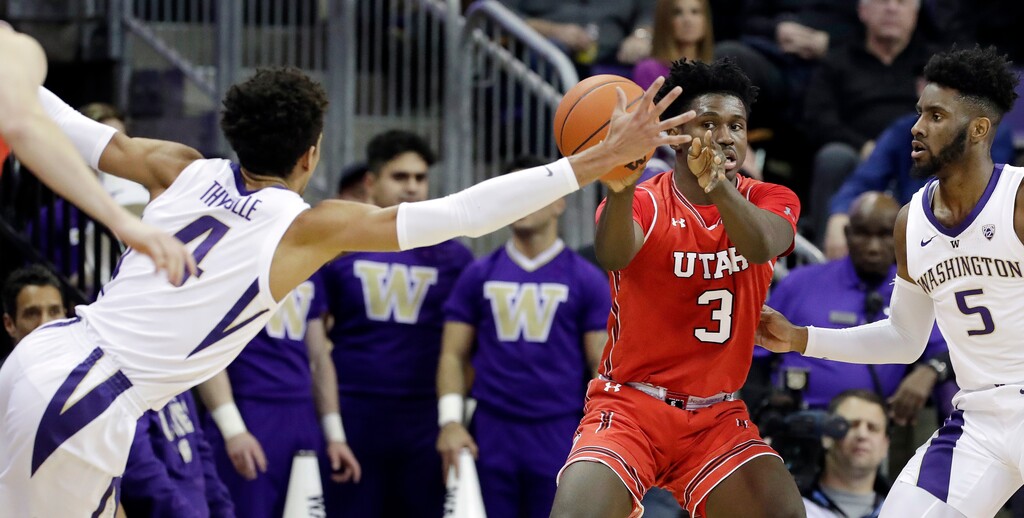 Washington's Matisse Thybulle (4) stretches across to try to stop a pass from Utah's Donnie Tillman (3) as Washington's Jaylen Nowell watches during the first half of an NCAA college basketball game Wednesday, Feb. 20, 2019, in Seattle. (AP Photo/Elaine Thompson)