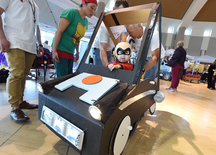 (Francisco Kjolseth  |  The Salt Lake Tribune)  Cooper Baskett, 3, assumes the role of Jack-Jack from the movie "The Incredibles" as a small army of volunteers and staff at Shriners Hospital for Children in Salt Lake put the finishing touches on his Incredimobile and those of another 27 patients in wheelchairs for Halloween, Wednesday, Oct. 17, 2018. Cooper, who has skeletal dysplasia, relished the attention, frequently flashing some of his character's signature moves. "This is something he gets to have all his own," exclaimed his mother, Tonya Baskett.