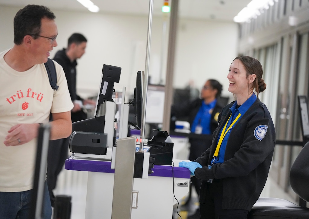 (Bethany Baker  |  The Salt Lake Tribune) A TSA agent laughs with a traveler at the Salt Lake City International Airport in Salt Lake City on Wednesday, Oct. 1, 2025.