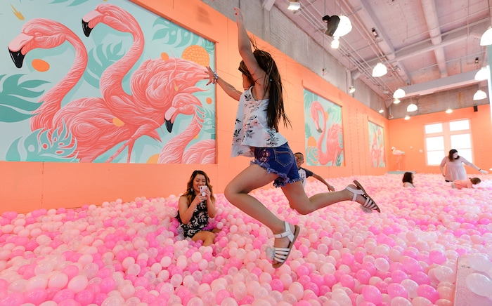 (Francisco Kjolseth  |  The Salt Lake Tribune)  Sam Bansasine photographs her daughter Danika Thackin, 6, as she jumps into a "giant neon fruit bowl" filled with balls at the Hall of Breakfast, a quirky new art exhibit that celebrates the first meal of the day.