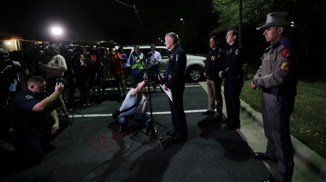 Interim Austin police Chief Brian Manley, center, talks to the media after an explosion, Monday, March 19, 2018, in Austin, Texas. The area around the explosion site has been blocked off and authorities are interviewing neighbors and searching for possible witnesses. (AP Photo/Eric Gay)