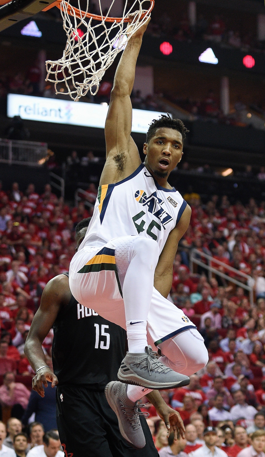 Utah Jazz guard Donovan Mitchell hangs from the rim after his dunk during the second half in Game 2 of an NBA basketball second-round playoff series against the Houston Rockets, Wednesday, May 2, 2018, in Houston. (AP Photo/Eric Christian Smith)