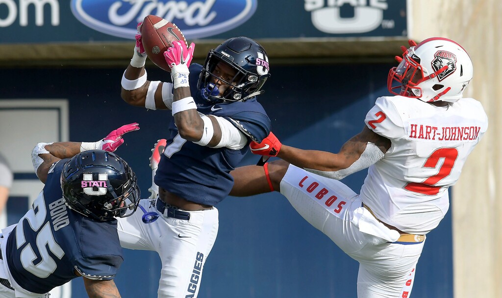Utah State cornerback DJ Williams (7) intercepts a pass intended for New Mexico wide receiver Delane Hart-Johnson (2) as safety Shaquez Bond (25) helps defend during an NCAA college football game, Saturday, Oct. 27, 2018, in Logan, Utah. (Eli Lucero/The Herald Journal via AP)
