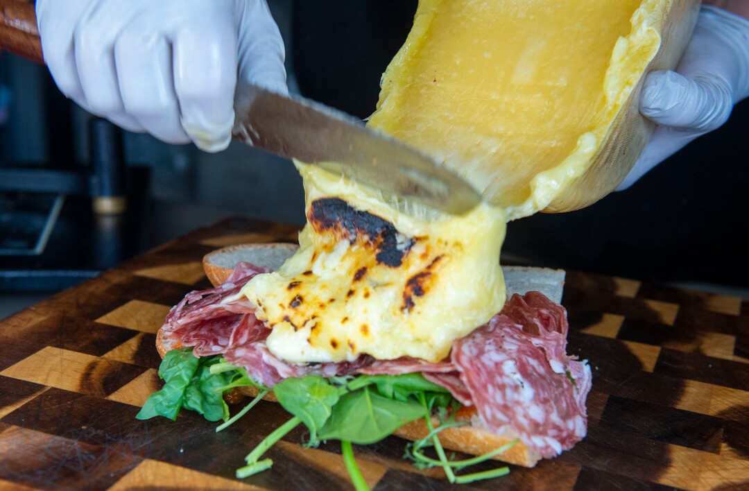 (Rick Egan  |  The Salt Lake Tribune)   Abby Pfunder slides off the melted cheese as she makes "The Alpine," in the Raclette Machine food truck, Wednesday, June 26, 2019. The food truck will be part of the Food Truck and Brewery Battle at The Gateway on Aug. 3.