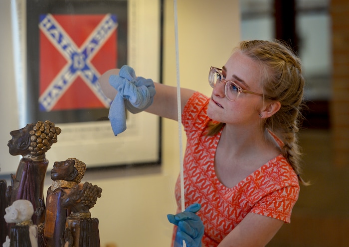 Leah Hogsten  |  The Salt Lake Tribune  Annie Boomer cleans a display case over artist Valerie Hellermann's porcelain figurines of Tibetan Buddhist Rinpoches titled who suffered inprisonment and torture under Chinese occupation of Tibet. The work is titled "Transmission," 2007 and is on display at the exhibit, "Speaking Volumes: Transforming Hate," opening Friday, June 15 at the Ogden Union Station Museum. The exhibit showcases 30 artists who transformed white-supremacist books into uplifting works of art.