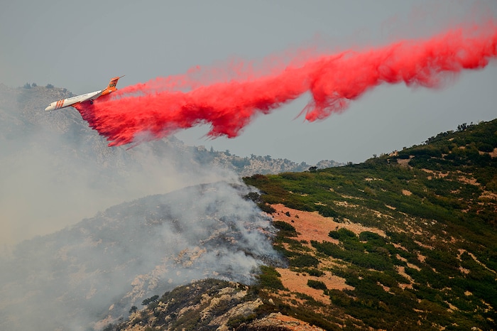 (Trent Nelson | The Salt Lake Tribune)  A plane makes a drop on a fire at the mouth of Weber Canyon, Tuesday September 5, 2017.