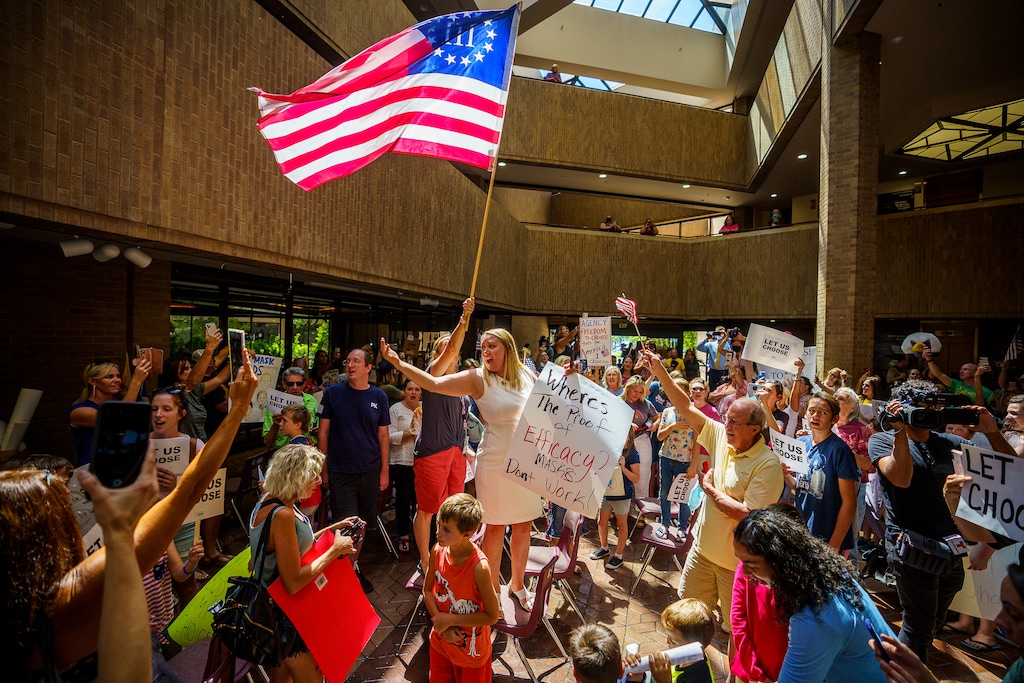 (Trent Nelson  |  The Salt Lake Tribune) People sing the national anthem under a Three Percenter flag after the Salt Lake County Council voted down Dr. Angela Dunn's mask ordinance for K-6 students, on Thursday, Aug. 12, 2021.