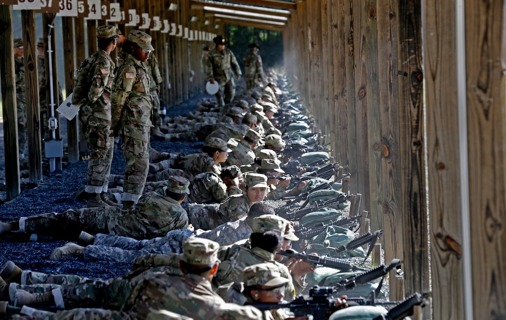 FILE - In this Aug. 17, 2016, file photo, Army drill sergeants stand over recruits during a live-fire marksmanship training course at Fort Jackson, S.C. Under the gun to increase the size of the force, the Army is pouring an extra $200 million into bonuses this year to attract and retain soldiers, and has approved more drug use and conduct waivers for recruits in order to build the ranks. (AP Photo/Gerry Broome, File)