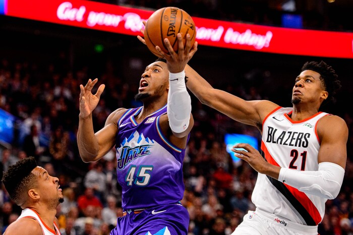(Trent Nelson  |  The Salt Lake Tribune) Utah Jazz guard Donovan Mitchell (45) shoots, defended by Portland Trail Blazers center Hassan Whiteside (21) as the Utah Jazz host the Portland Trail Blazers, NBA basketball in Salt Lake City on Thursday, Dec. 26, 2019.