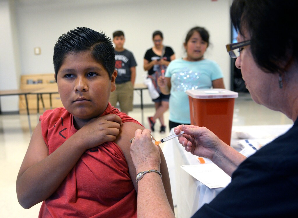 (Al Hartmann  |  Tribune file photo) In this July 15, 2015, file photo, Alexis Herrera, 11, remains tough as he gets an immuzation shot for school at the Junior League CARE Fair in the Horizonte Center in Salt Lake City. Utah has the sixth highest rate in the nation for children without health care coverage, a new report says, and the problem has been growing.