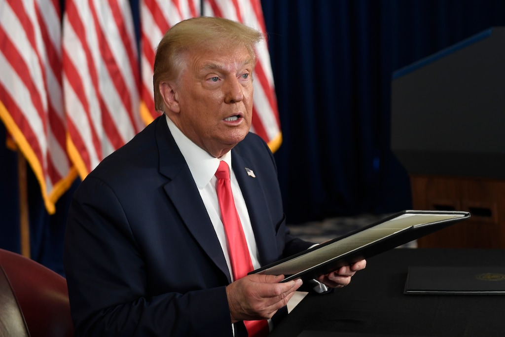 (Susan Walsh | AP file photo)  President Donald Trump prepares to sign four executive orders during a news conference at the Trump National Golf Club in Bedminster, N.J., on Aug. 8, 2020.