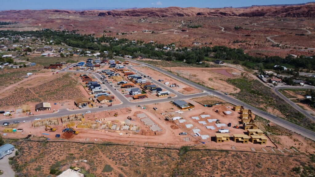 (Utah Housing Corporation) Confluence Cottages and Skyline Arch Apartments under construction at Arroyo Crossing in September 2024. Skyline has since been completed and is occupied, while Confluence is now nearing completion.